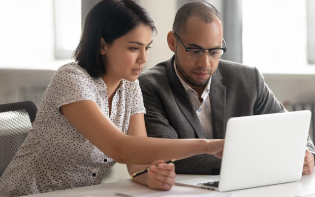 Woman showing man laptop