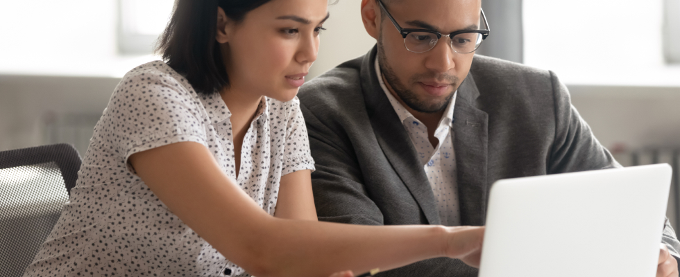 Woman showing man laptop