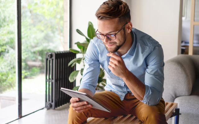 Man sitting down looking at tablet