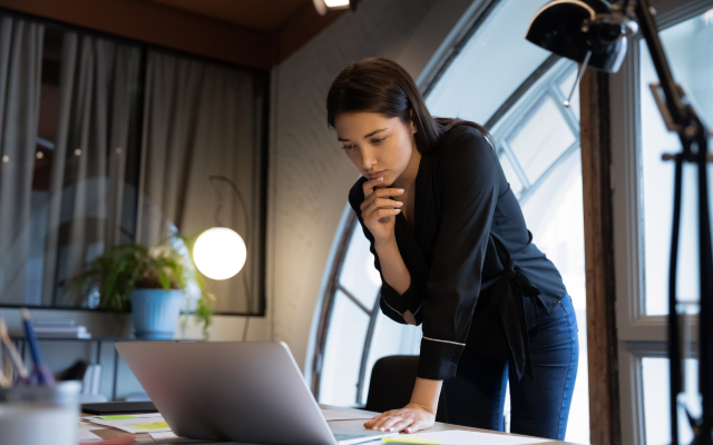 Woman standing over laptop