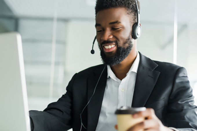 man wearing headset working at laptop screen