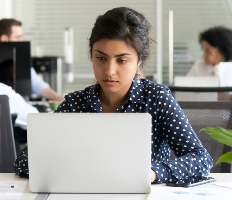 woman sitting at desk looking at laptop