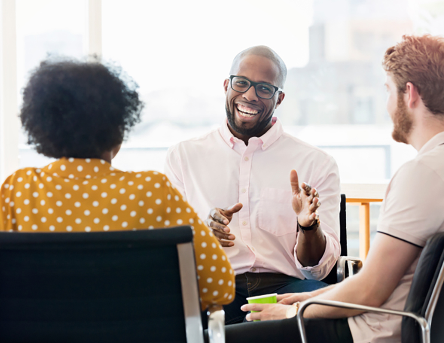 four people sitting at table talking