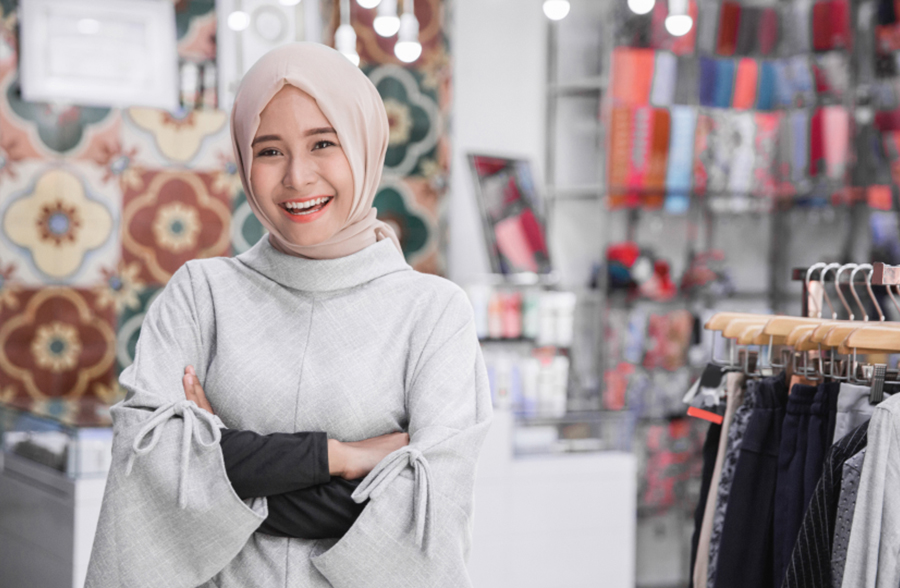 Woman wearing headscarf standing in shop smiling