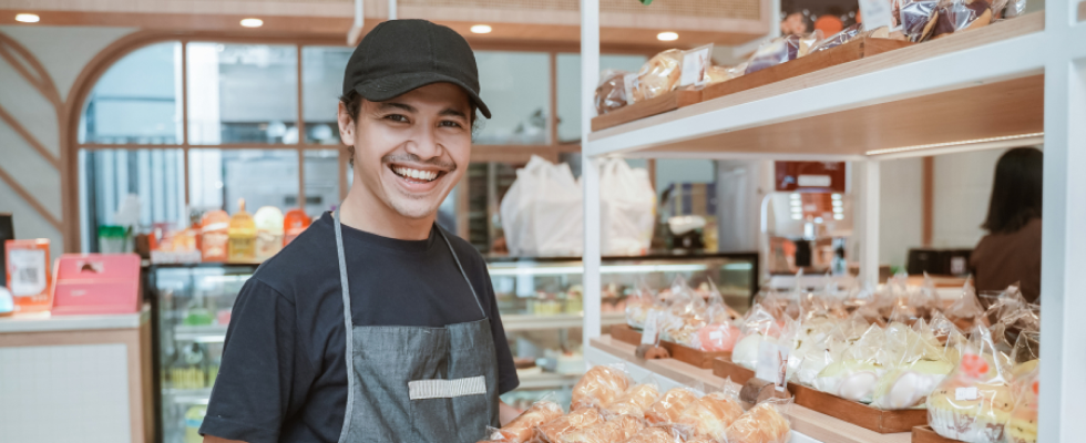 Man standing in bakery smiling