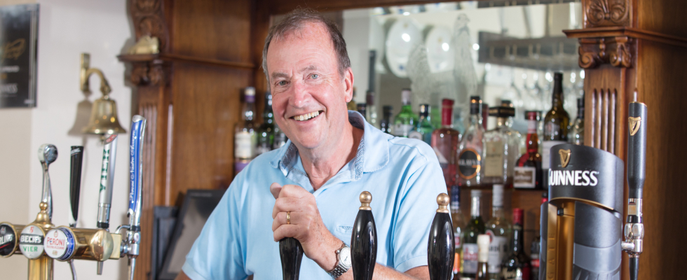 man pulling pint smiling in pub
