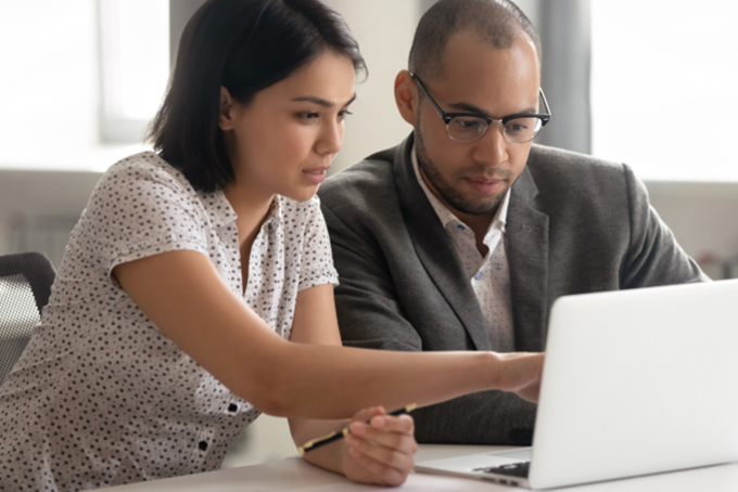 man and woman sitting at laptop working