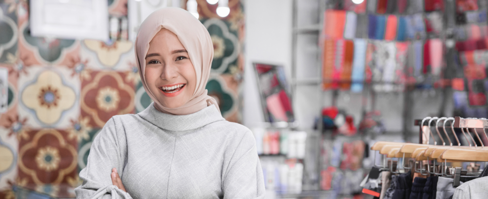 Woman wearing headscarf standing in shop smiling