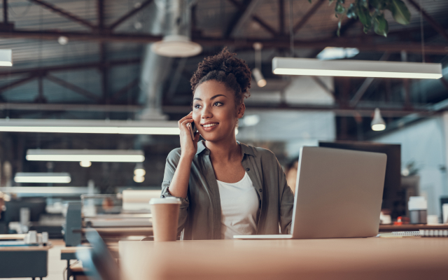 Woman sitting at desk, on the phone