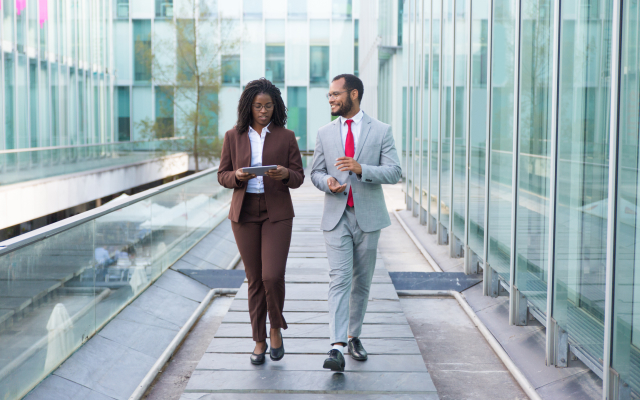 Man and woman walking down glass corridor