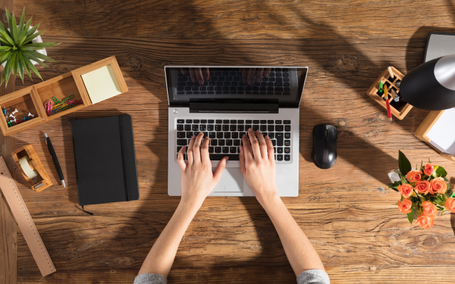 Bird's-eye view of person typing on laptop