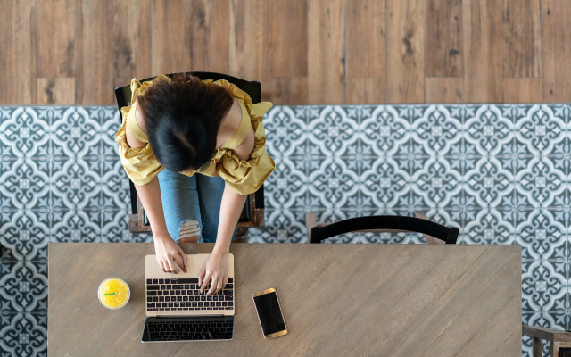 Bird's-eye view of person typing on laptop