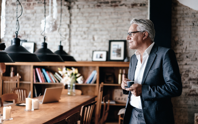 Man standing in café with cup of coffee