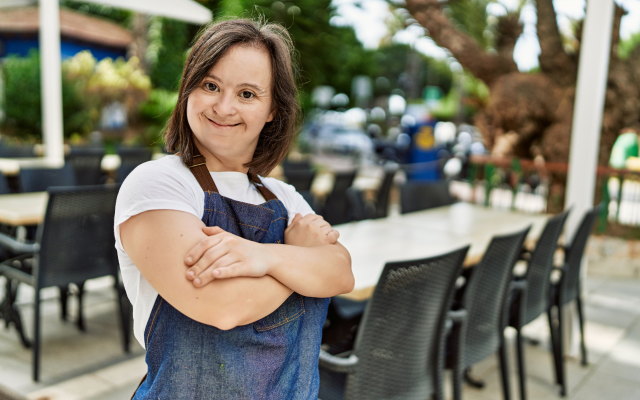 Woman standing with arms folded in restaurant