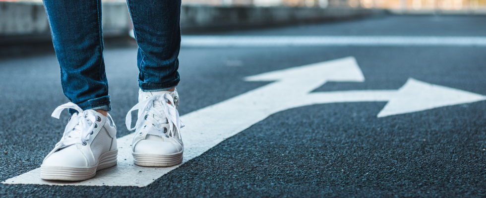 Person standing on arrow road marking