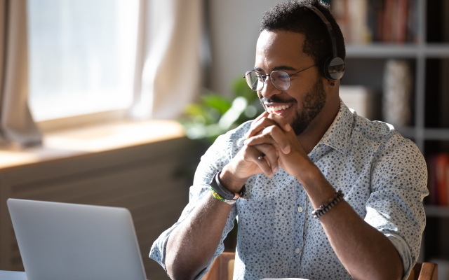 man working at laptop smiling