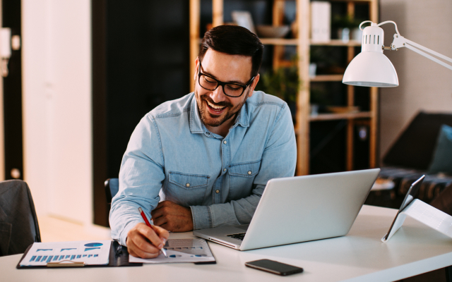 man sitting at desk working on laptop