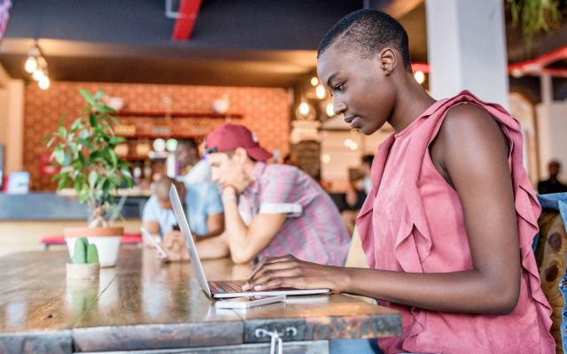 Woman looking at laptop in a coffee shop