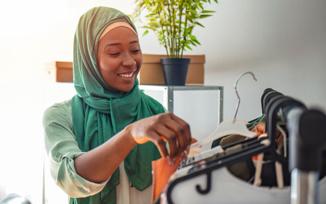 Woman with headscarf looking at clothes on a rack