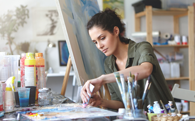 Young woman painting at desk