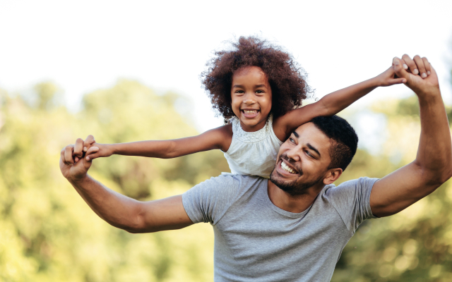 smiling kid on father's shoulders