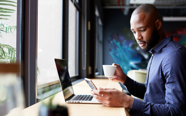 Man at desk looking at smartphone