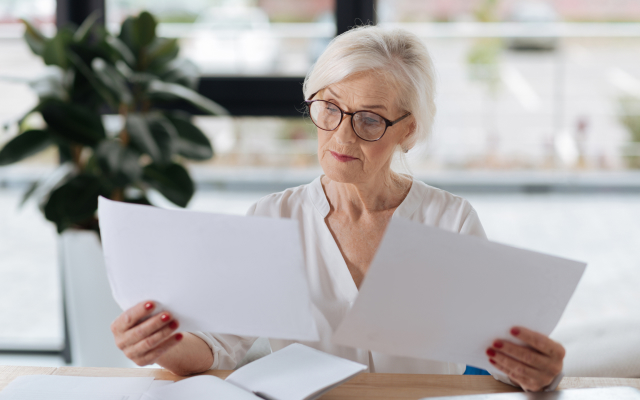 Woman sitting at table looking through paperwork