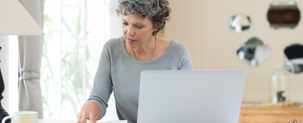 Woman sitting at desk, looking at receipts