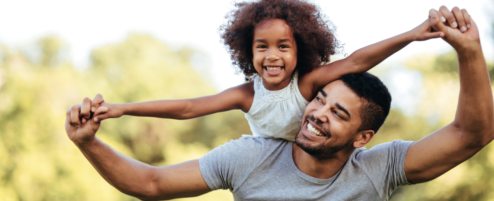 Man carrying child on his back