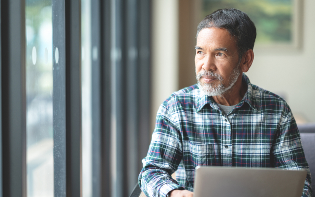 Image of man sitting at desk looking out the window