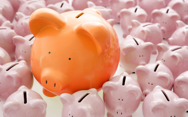 Orange piggy bank surrounded by mini piggy banks