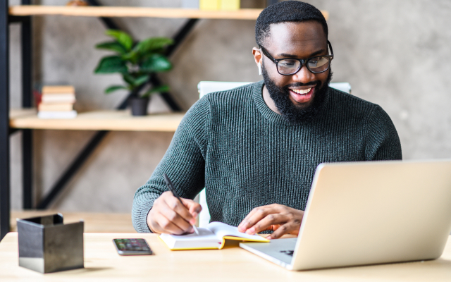 Man sitting at desk looking at laptop screen